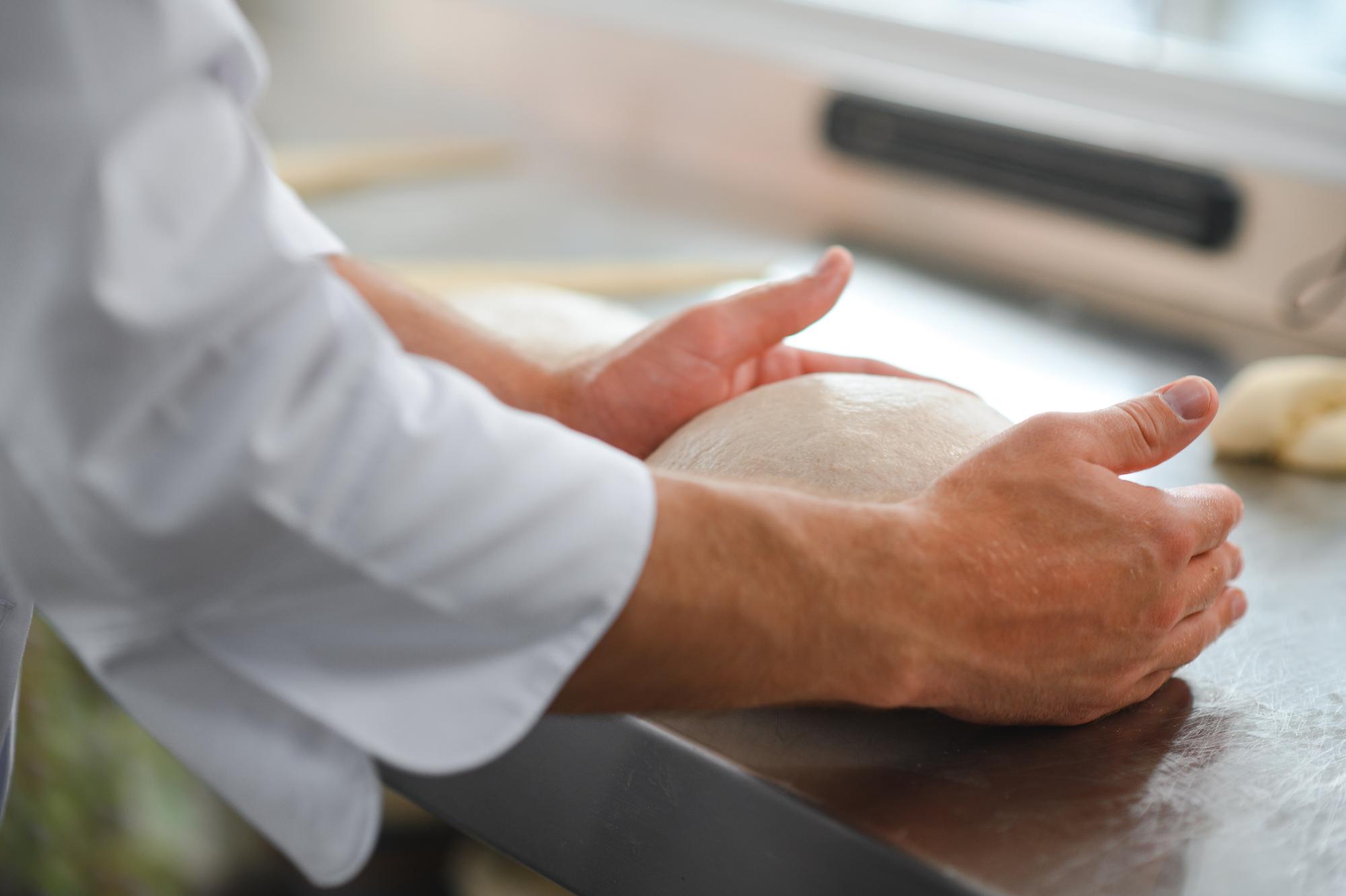 Dettaglio: mani che impastano pane